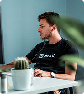 A man sitting at his desk with headphones on.
